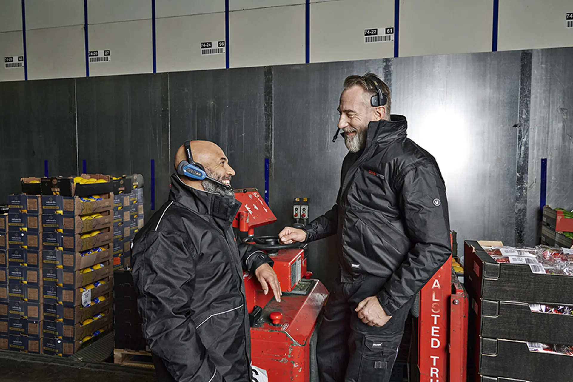 Medarbejdere i samtale foran truck på lager