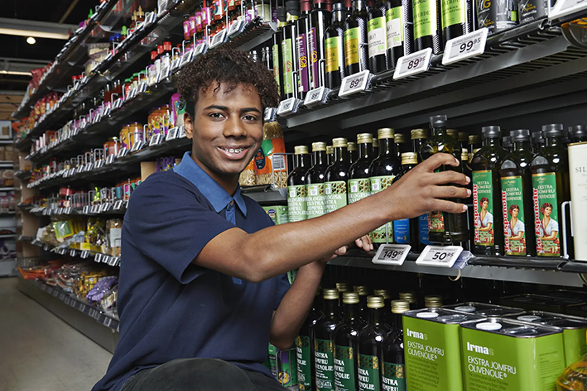 Medarbejder trimmer varerne på hylden